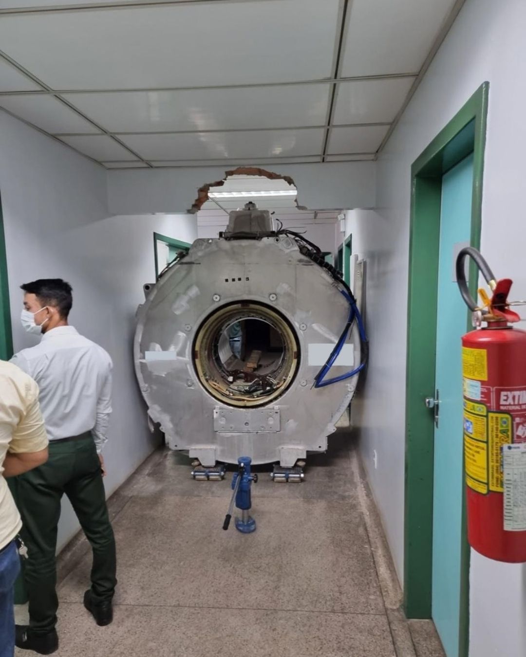 Equipe técnica avaliando o ativo antes da movimentação no corredor do hospital